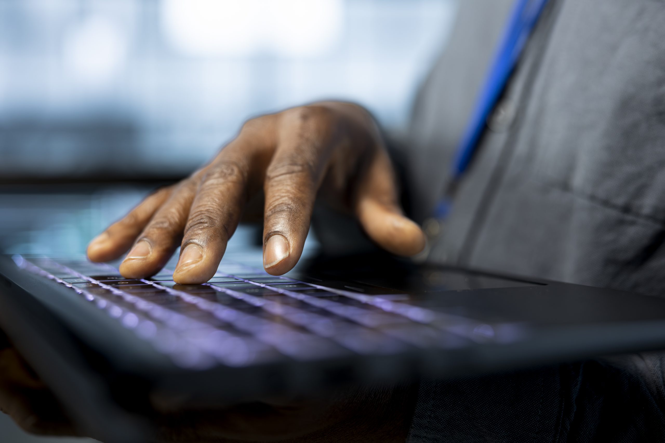 Admin in data center typing on notebook keyboard, using automation tools, doing predictive maintenance. Close up of IT specialist ensuring continuous uptime of server farm, managing data flows